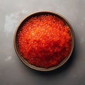 From above red fresh trout fish caviar served in a bowl on concrete table background