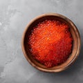 From above red fresh trout fish caviar served in a bowl on concrete table background