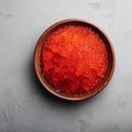 From above red fresh trout fish caviar served in a bowl on concrete table background