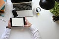 Above shot businessman holding a computer tablet with white blank screen in hands at the modern white table. Royalty Free Stock Photo