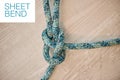 Above shot of hiking rope tied in a knot against a wooden background in studio. Sheet bend knot, A knot for every