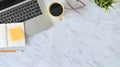 Above shot table, Office desk marble table with laptop, notebook paper, pencil, glasses and coffee cup. Royalty Free Stock Photo