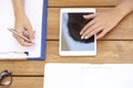 From above shot of woman`s hand touching digital tablet and writ Royalty Free Stock Photo