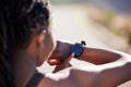 Above shot of a young african american female athlete checking her smartwatch while exercising outdoors. Closeup shot of Royalty Free Stock Photo