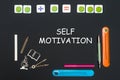 Above stationery supplies and text self motivation on blackboard