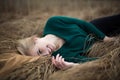 Above view of beautiful redhaired girl lying on grass, posing, embracing. Autumn forest with yellow grass. Woman with long hair, Royalty Free Stock Photo