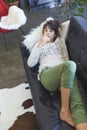 Above view of a beautiful young woman lying on leather couch relaxing while looking away at home Royalty Free Stock Photo