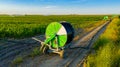 Aerial view on irrigation reel, agricultural water sprinkler, sprayer, sending out jets of water to irrigate corn farm crops Royalty Free Stock Photo