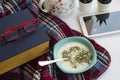 A bowl of soup with,old book,tablet,reading glasses and wool blanket on white surface. Royalty Free Stock Photo