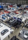 From above, the view captures the bustling activity of a car show, teeming with people exploring the latest automobile designs and Royalty Free Stock Photo