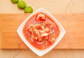 Above view of delicious traditional ecuadorian shrimp cebiche in rectangular white bowl, with lemon, served over a