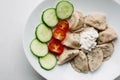 Pirogi with different fillings, cucumber, tomato and cream.