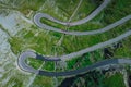 Above view of epic winding road on Transfagarasan pass in Romania in summer time, with twisty road rising up. Road crossing