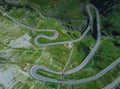 Above view of epic winding road on Transfagarasan pass in Romania in summer time, with twisty road rising up. Road crossing