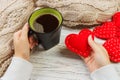 Above view of female hand holding hot cup of coffee with red heart on wood table. Photo in vintage color image style Royalty Free Stock Photo