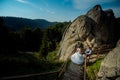 Above view of the glamour bride going down the wooden stairs to the blond groom. Mountains location. Beautiful nature Royalty Free Stock Photo