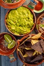 Guacamole and tortilla chips in vintage red clay pots