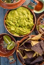 Guacamole and tortilla chips in vintage red clay pots