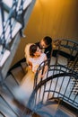 The above view of the groom hugging the bride back while standing on the stairs. Royalty Free Stock Photo