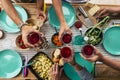 Above view of group of friends people eat and drink together celebrating and having fun toasting with red wine - coloured table Royalty Free Stock Photo