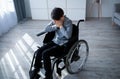 Above view of handicapped adolescent in wheelchair crying at home. Depression and loneliness in disabled teens concept Royalty Free Stock Photo