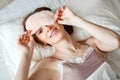 From above, a view of a healthy young woman laughing, removing her sleeping mask after a good night`s rest is filmed. A Royalty Free Stock Photo