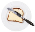 Above view of knife on bread and butter on plate Royalty Free Stock Photo