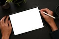 Male graphic designer using digital tablet with a stylus pen on black workspace Royalty Free Stock Photo