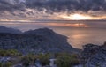 Above view of a mountain coastline at sunset in South Africa. Scenic landscape of dark clouds over a calm and peaceful Royalty Free Stock Photo