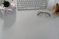 Office desk with keyboard, glasses, headphone and copy space on white background. Royalty Free Stock Photo