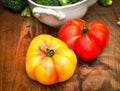 Whole red and yellow heirloom tomatoes on wood cutting board Royalty Free Stock Photo