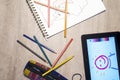 Above view of open exercise book, pencil crayons and tablet on w Royalty Free Stock Photo