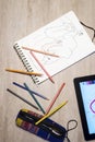 Above view of open exercise book, pencil crayons and tablet on w Royalty Free Stock Photo