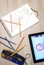 Above view of open exercise book, pencil crayons and tablet on w Royalty Free Stock Photo