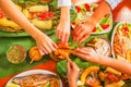 Above view of people eating the assorted food, grilled meat with potato, sweet tomatos, salad, pepper, fried plantain Royalty Free Stock Photo