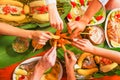 Above view of people eating the assorted food, grilled meat with potato, sweet tomatos, salad, pepper, fried plantain Royalty Free Stock Photo