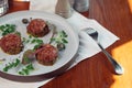 Beef tartar with an egg on a stone plate. Cherry tomatoes. Rosemary. Spice. Royalty Free Stock Photo