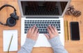 Above view of senior woman`s hands working on laptop. Wooden table. Alternative outdoor office. Cellphone and headphones close to Royalty Free Stock Photo