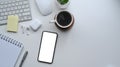 Smart phone with empty screen, wireless earphone and coffee cup on white desk. Royalty Free Stock Photo