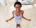 Above view of smiling young black woman standing on scales and measuring her waist at home Royalty Free Stock Photo