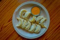 Above view of steamed Momo served in a white plate. A popular Nepalese food that is also common in Chiana, Bhutan, Tibet