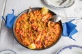 Above view of typical Spanish paella with seafood mussel, prawn, lobster, squid, clam, rice and lemon ready to serve on white