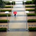 Above view of an unidentifiable businessperson walking on sidwalk with a red umbrella Royalty Free Stock Photo