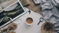 Above view of the vintage composition of the cup of coffee, magnifying glass, book with paitings, tissues and straw