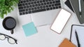 White office desk smart phone, laptop computer, glasses, coffee cup, sticky note and notebook. Royalty Free Stock Photo