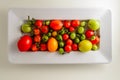 Above view of a white tray of red and green fresh picked tomatoes Royalty Free Stock Photo