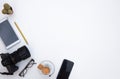 Above view of a white workplace. No people. A cup of coffee to make a break. Technological devices and camera Royalty Free Stock Photo