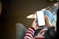 Above view, A woman using her smartphone while relaxes sitting on an armchair Royalty Free Stock Photo