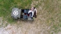 Overhead, drone, looking down on Male army officer in uniform resting on back of military vehicle