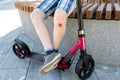 Abrasions, bruises on the knees of unrecognizable teenager with kick scooter. Life of teenagers